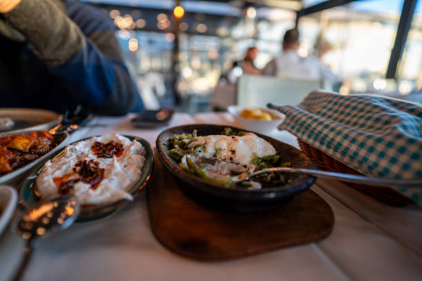 aegean appetizers are foreground focus on foreground in restaurant and customers are back ground horizontal food business still