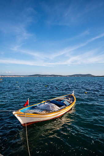 fishing boat is on aegean sea blue sunny sky vertical landscape still. Ayvalık, Balıkesir, Turkey, 2024