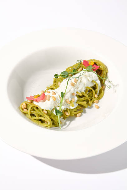 istock Spaghetti with Pesto Sauce and Stracciatella Cheese, Shadow of a Leaf on White, Ideal for Seasonal Menu Features 2002139426