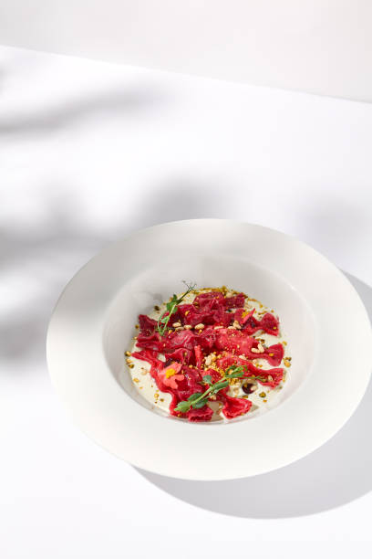 istock Beetroot Ravioli Bows with Cream Sauce and Leaf Shadow, Elegance on a Plate for Fine Dining Experiences 2002139428