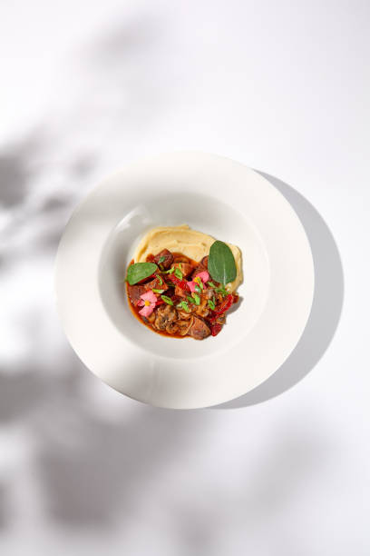 istock Braised beef with vegetables and mushrooms with a creamy mashed potato background, topped with shadow play for an enticing visual feast 2002139965