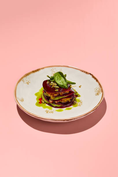 istock Beetroot mille-feuille with pesto sauce on a chic plate against a coral pink backdrop, a delight for gourmet vegetarian cuisine 2002139979