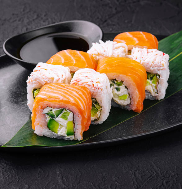 istock sushi rolls with salmon and crab on black plate 2002152632