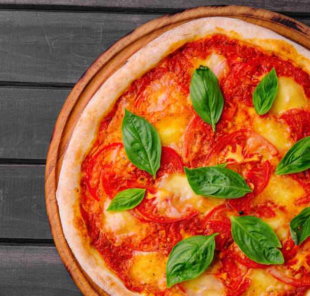 istock Pizza Margherita on black wood background 2002153172