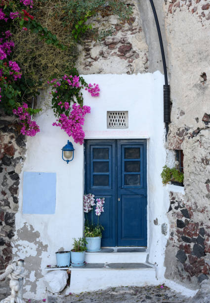 istock Blue antique door surrounded by flowers. Mediterranean atmosphere. 2002158381