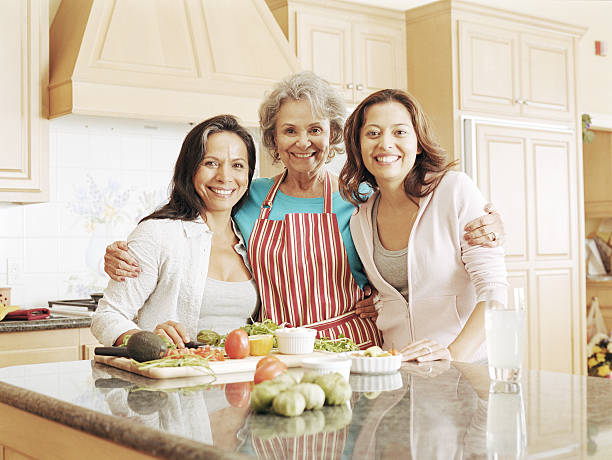 tres generaciones familia preparando la comida en la cocina, vertical - grandmother standing senior women senior adult fotografías e imágenes de stock