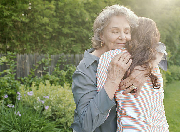 Grandmother embracing adult granddaughter  granddaughter stock pictures, royalty-free photos & images