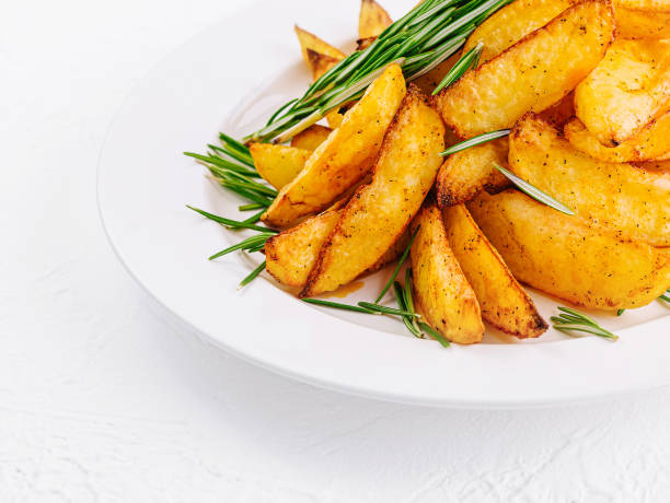 istock Baked potato wedges with rosemary on plate 2002172528