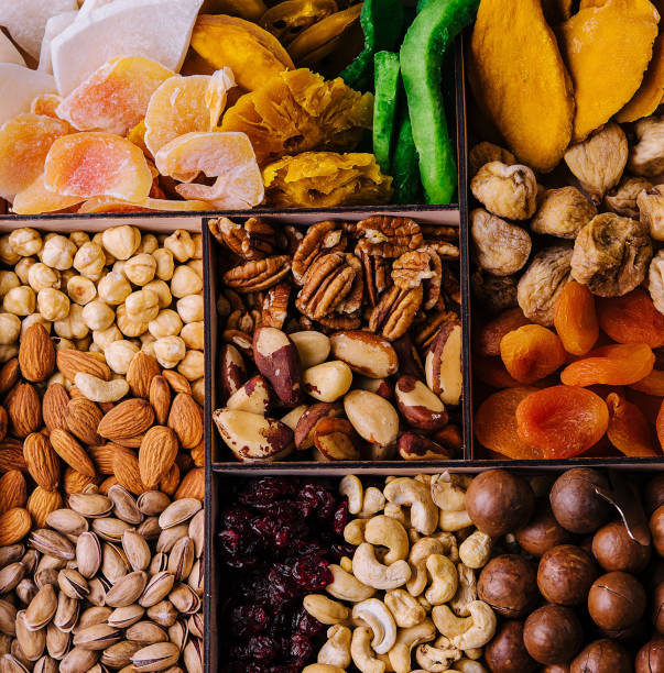 istock Assorted nuts and dried tropical fruits in a wooden box 2002177814