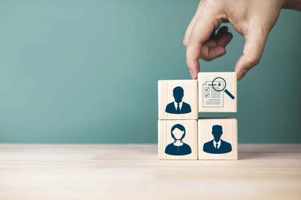 istock Candidate selection and evaluation. Wooden blocks with human icons and personal assessment documents. 2002208501