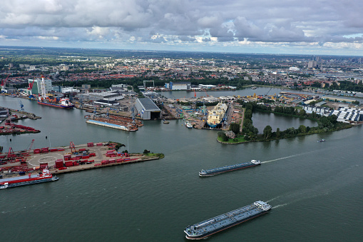 The Port of Rotterdam is the largest seaport in Europe, and the world's largest seaport outside of East Asia. The image shows as high angle view several container terminals. Captured during summer seosin with cloudy sky.