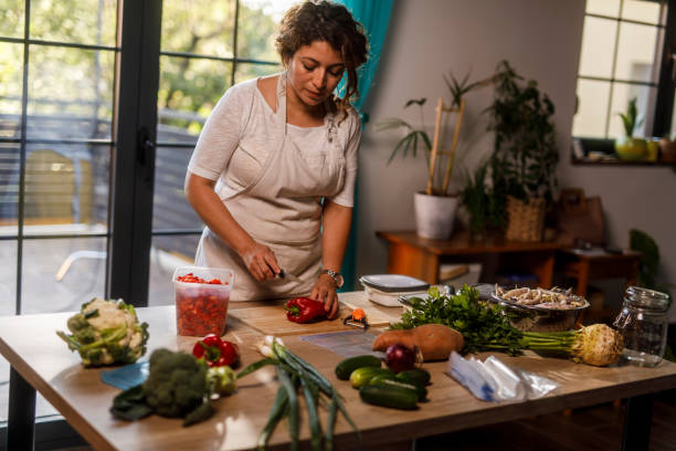 istock Homemaker chopping and preparing various vegetables for winter preservation 2002215267