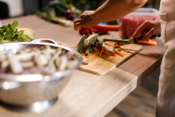 istock Woman chopping various veggies at her kitchen table 2002244961