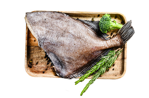 Raw fresh John Dory fish on a wooden tray with rosemary and broccoli.  Isolated on white background. Top view