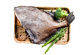 Raw fresh John Dory fish on a wooden tray with rosemary and broccoli. Isolated on white background. Top view.