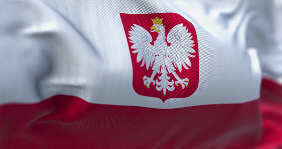 Close-up of Poland national flag waving in the wind. Two horizontal stripes, white on top and red on bottom, with the Polish coat of arms in the center. 3d illustration render. Rippling textile