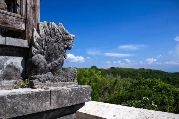 Balinese traditional carved stone statue in front of temple of uluwatu
