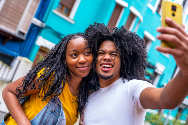 istock Young african couple pulling faces taking selfie int he city 2002326895