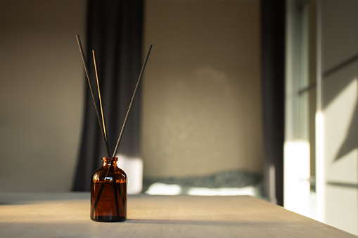 Aromatherapy in the bedroom, diffuser with scent sticks, cozy home ambiance, air freshener