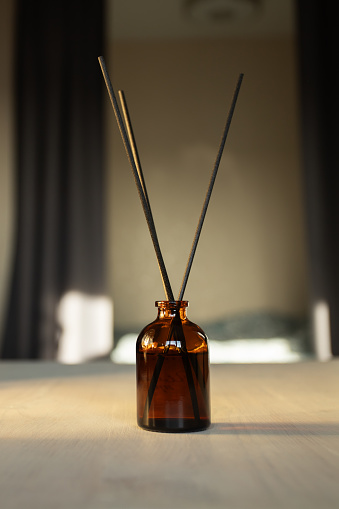 Diffuser in the bedroom interior, aroma oil vial, relaxing atmosphere, therapeutic scent