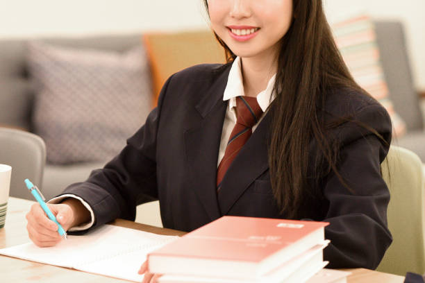 Asian female student wearing school uniform and studying indoors