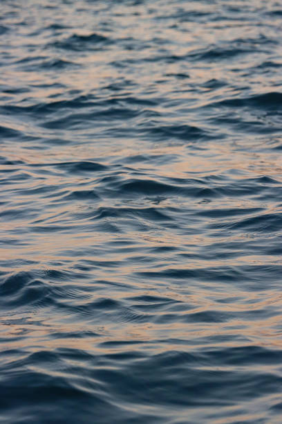 Stock photo showing some rippling waves on the surface of the sea, which are creating their own shadows and reflecting sunlight.