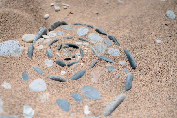Stones on the sandy beach in a spiral shape