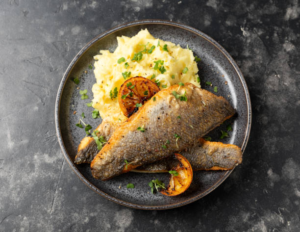 istock Pan fried sea bass fillets served with mashed potatoes and caramelised lemon 2002361844