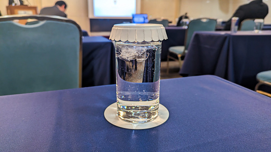 Glass filled with cold water in office meeting room
