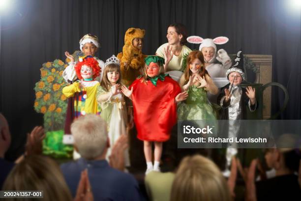 Kinder Tragen Kostüme Und Lehrer Winken Auf Der Bühne Stockfoto und mehr Bilder von Aufführung