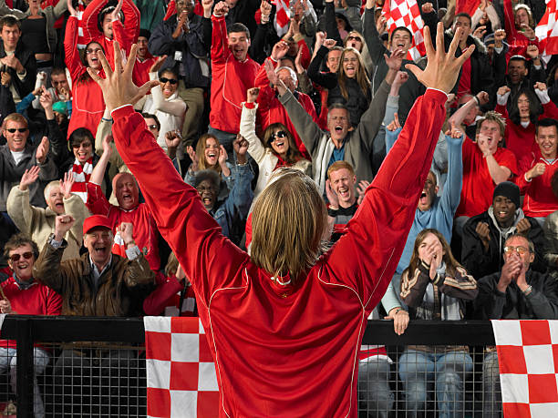 footballeur lever les bras devant acclamations foule, vue de dos - flag checkered flag sports race checked photos et images de collection