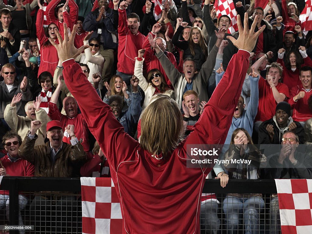Футболист поднимая руки перед радость толпа, вид сзади - Стоковые фото Известность роялти-фри