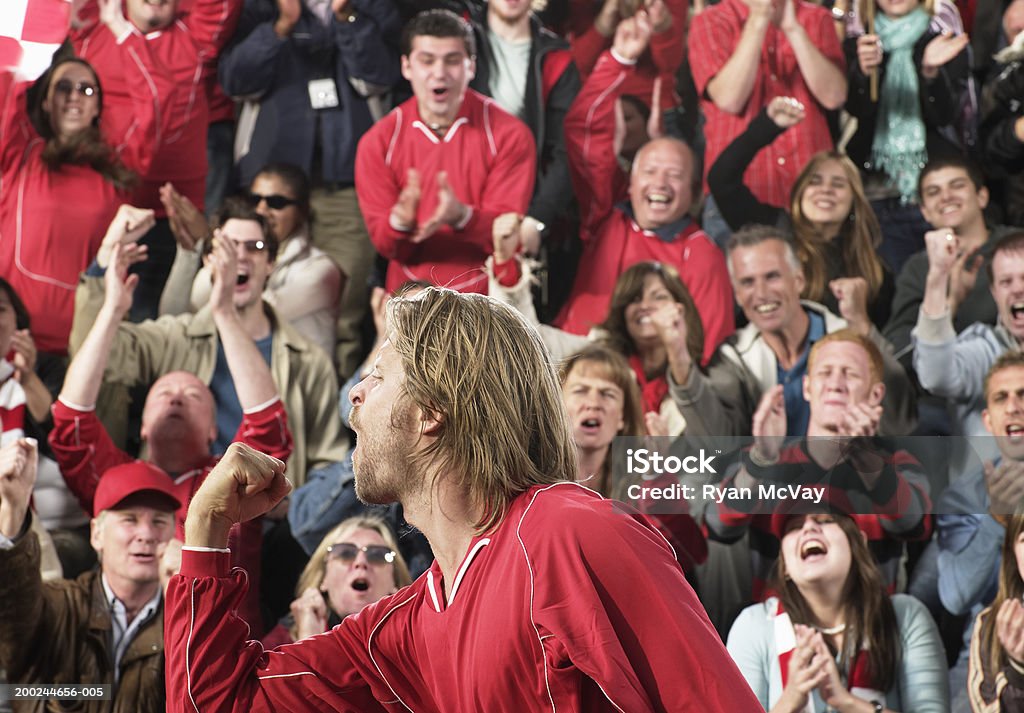 Footballeur célébrant devant acclamations foule, vue latérale - Photo de Festivité libre de droits