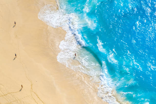 istock Beautiful ocean waves and white beach with people from top. 2002457976