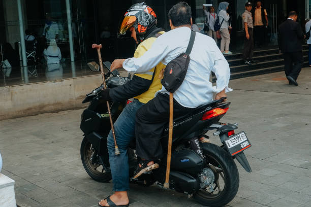 rear view of a disabled person riding an online motorcycle taxi - bus riding public transportation businessman imagens e fotografias de stock