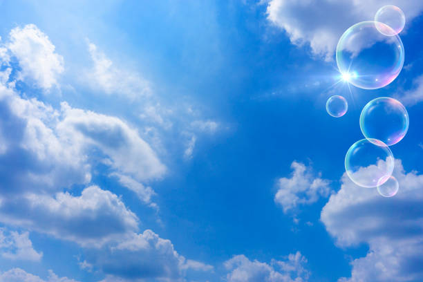 Many soap bubbles going up into the blue sky