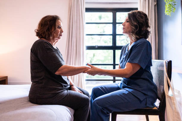 istock Healthcare worker doing breathing exercise with patient at home 2002504093