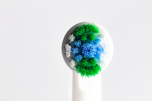Close up macro color image depicting a new electric toothbrush head on a white background.