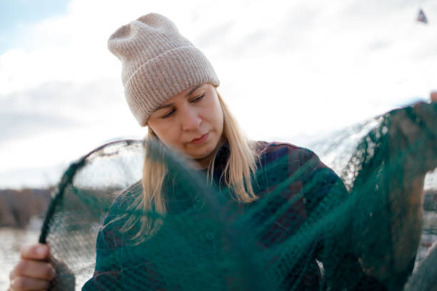 marynarka kobieta trzymająca sieć rybacką - fishermen harbor zdjęcia i obrazy z banku zdjęć