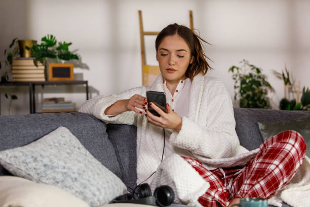 istock Sitting on the sofa in pjs and checking social media on smart phone 2002535247