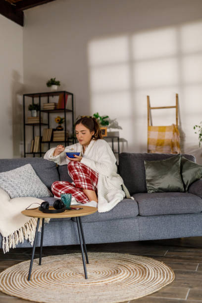 istock Young woman eating cereal for breakfast 2002535257