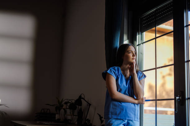 istock Nurse standing by the window, arms crossed, contemplating 2002540972