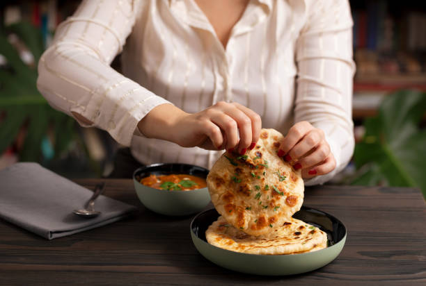 Young woman eating curry and naan bread