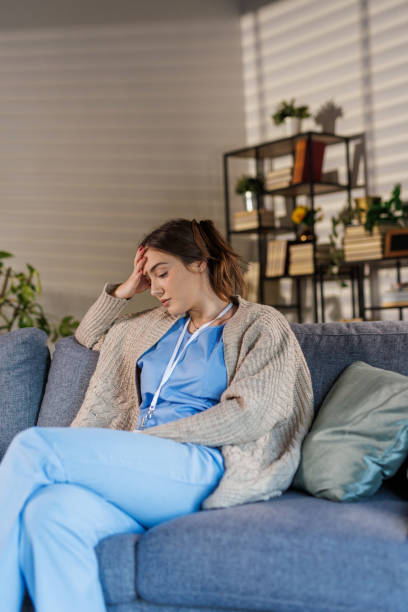 istock Tired nurse simply sitting on the sofa and resting after coming home from work 2002549775