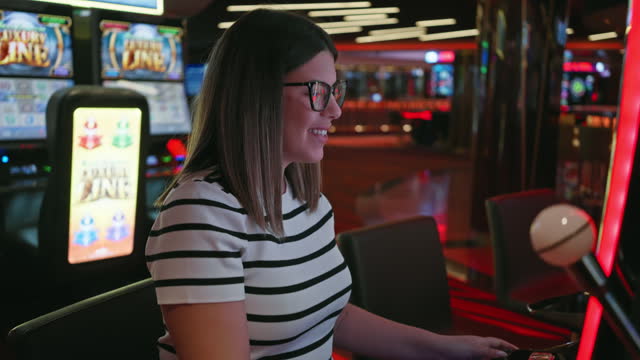 Smiling woman playing slot machines at a vibrant casino