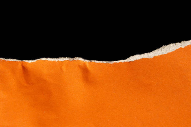 istock Ripped orange paper isolated on black background 2002577279