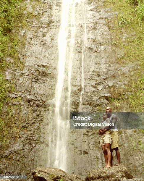 Photo libre de droit de Couple Embrassant Et Souriante En Cascade banque d'images et plus d'images libres de droit de Cascade - Cascade, Aventure, Kailua