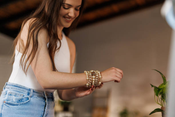 Young woman putting on a necklace when getting ready