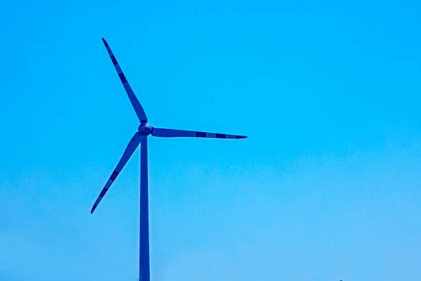 wind power plant silhouetted against the blue evening sky. Crisis Saving electricity