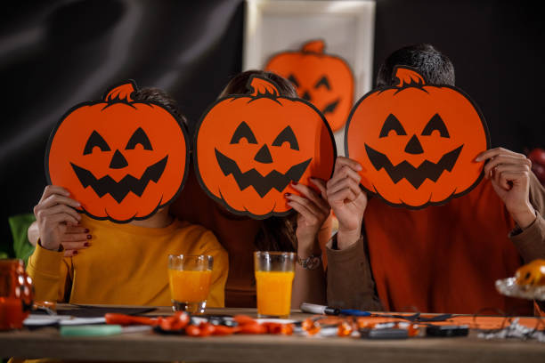 famille de trois personnes souriant à la caméra avec des masques jack o' lantern - 12 15 months photos et images de collection